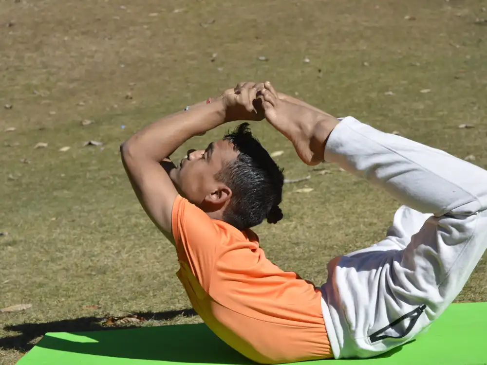 Bow pose practised on a hillside meadow in Himachal