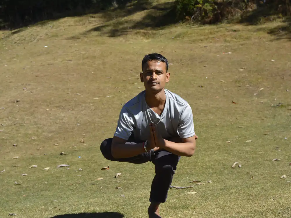 A standing balance held on open hillside grass above Shimla